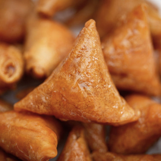 Close-up of triangular fried snacks with a glossy finish